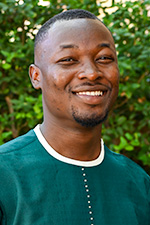 Kwabena Bayity, Graduate research assistant headshot in front of green foliage