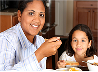 Image of mother and daughter eating  a healthy breakfast