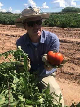 Image of Dr. Marsalis holding a big red tomato