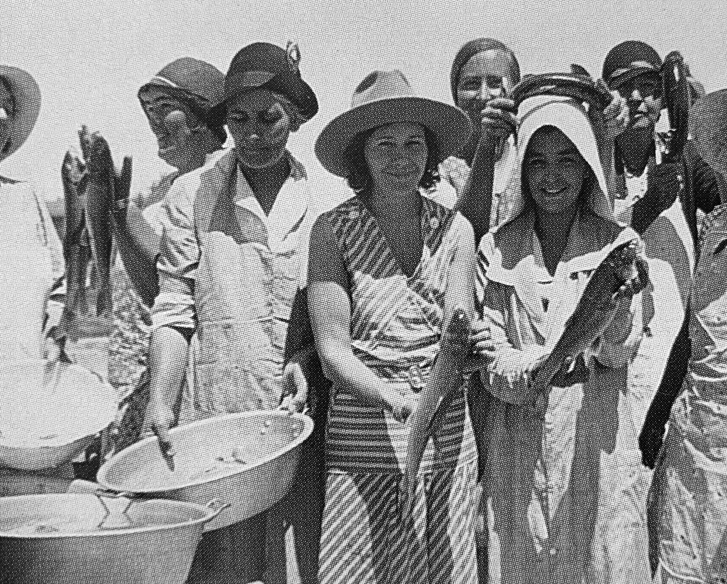 Group of women holding fish and pots