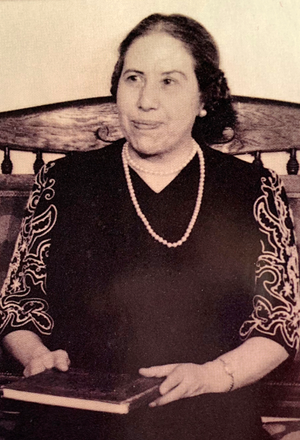 Fabiola Cabeze de Baca sitting in chair with a book on her lap.